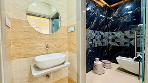 Un baño con un lavamanos blanco, un espejo y una pared de mármol.