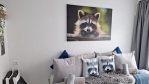 Una camera da letto con set di cuscini a tema tasso, una fotografia a parete raffigurante un tasso e una tenda grigia.