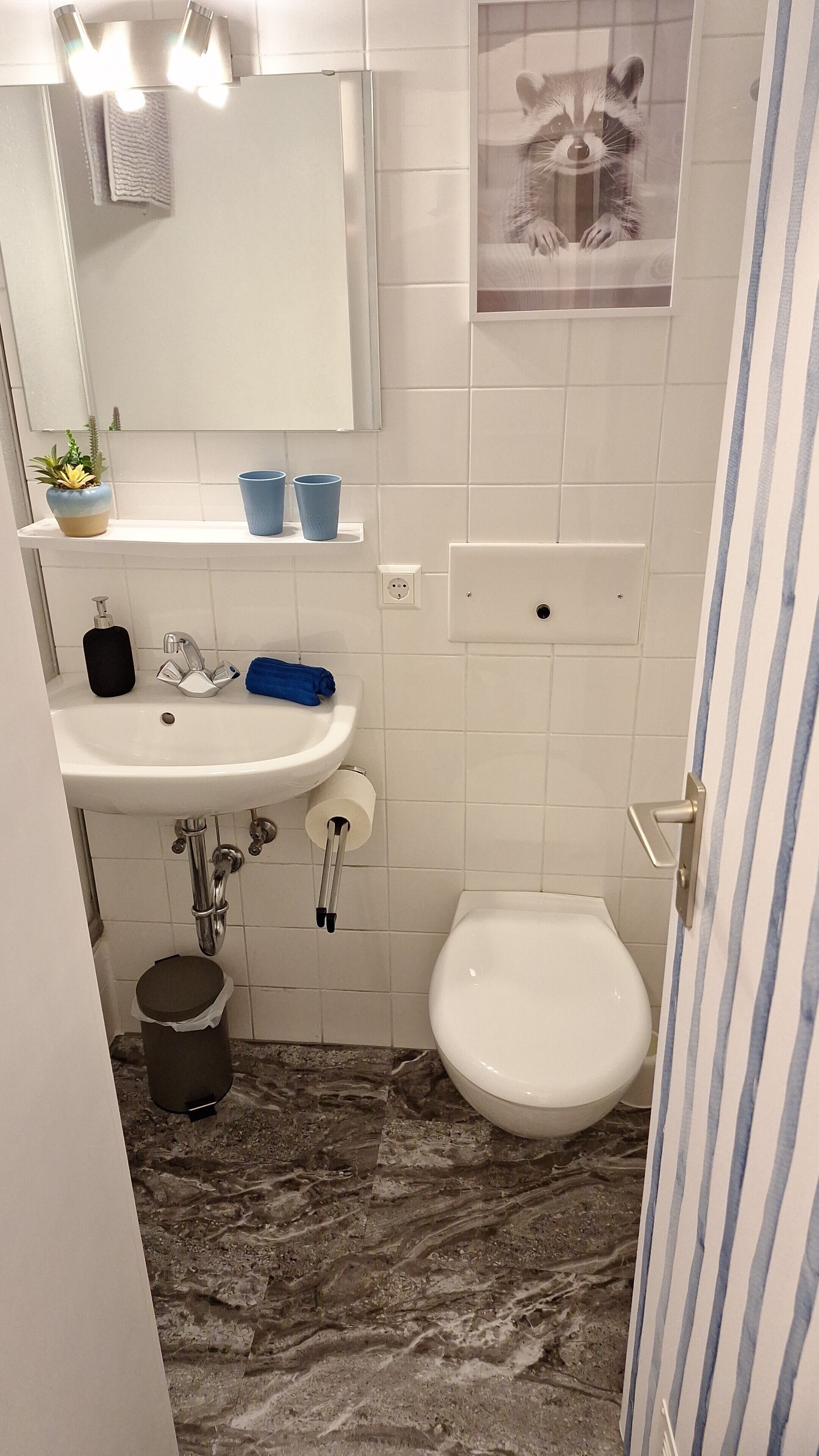 Ein Badezimmer mit Waschbecken, Spiegel, Toilette und Mülleimer.