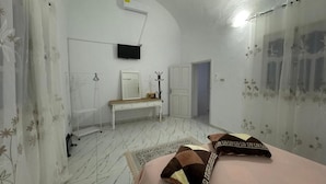 A bedroom with a bed, a desk, a chair, a wardrobe, and a television on the wall. - Djerba 7 Exclusive Stay with Daily Homemade Brunch (Aghir)