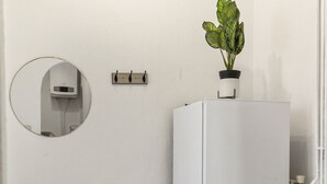 A bathroom with a white cabinet, a round mirror, and a potted plant on top of the cabinet. - Comfy 2BR Apartment Long Stay Downtown (Vienna)