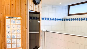 A sauna area with a wooden wall, a clock, and a poster with instructions. - Apartment Nathalie – Wellness with Pool and Sauna (Schluchsee)