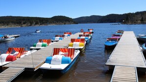 A dock with rowboats and lounge chairs. - Apartment Nathalie – Wellness with Pool and Sauna (Schluchsee)