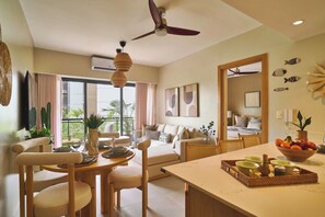 Ein modernes Wohnzimmer mit Essbereich, Deckenventilator und Blick ins Freie.