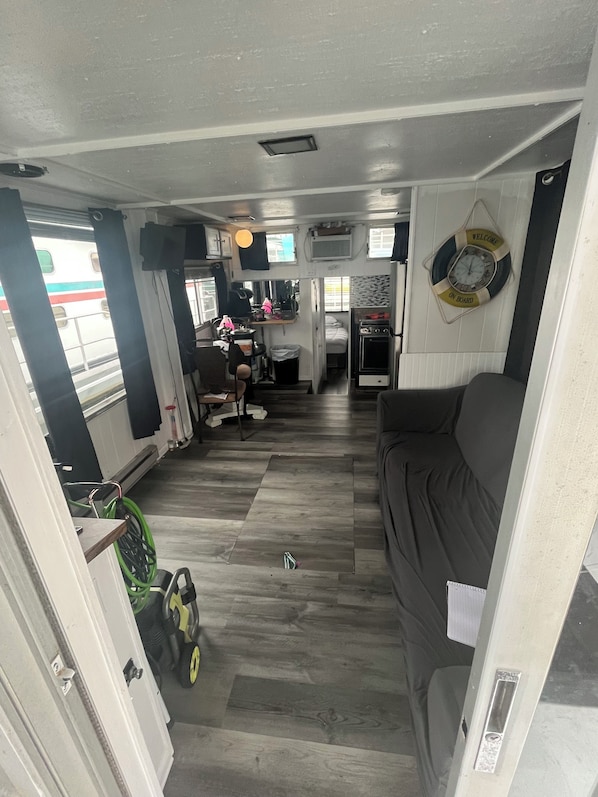 A compact living space with a sofa, kitchenette, and a small dining area.