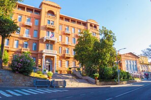 Ein mehrstöckiges Hotel im klassischen Baustil, mit Balkonen und einem prachtvollen Eingang.