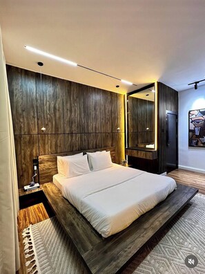 Un dormitorio moderno con una cama grande, paneles de madera y un espejo.