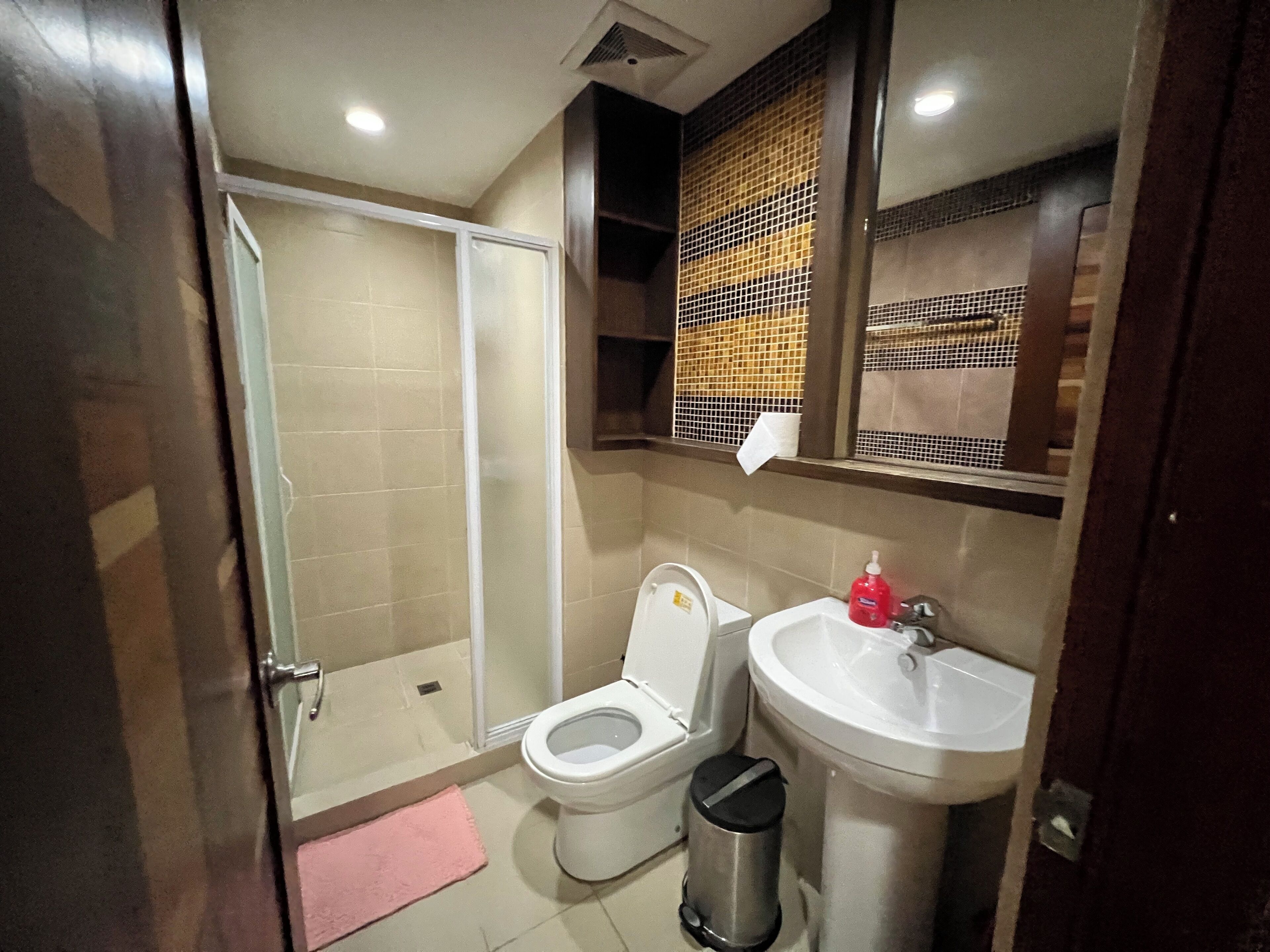 Een badkamer met toilet, wastafel en douche.