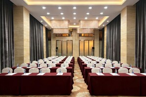 A conference room with rows of tables and chairs, equipped with water bottles and nameplates. - Green Jinyi hotel (Nanchang)