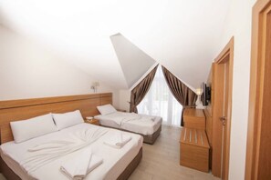 A hotel room with two beds, wooden headboards, a flat-screen TV, and a large window with curtains. - Elit Life Hotel - All Inclusive (Kemer)