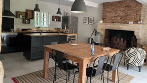Una cocina moderna con una isla central, armarios negros e iluminación colgante.