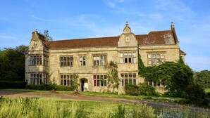 Ein großes, historisches Steinhaus mit zahlreichen Fenstern und einem markanten Eingang.