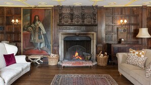 Ein traditionell eingerichteter Raum mit Kamin, Holzwänden und klassischem Mobiliar.