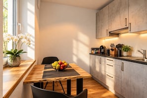 Een moderne keuken met een houten eettafel, een fruitschaal en een potorkidee.