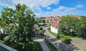 Een stad met een opvallende kerk, geplaveide straten en weelderige begroeiing.