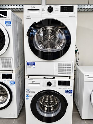 Een stapel witte wasmachines met digitale displays en bedieningspanelen.