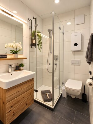 Een moderne badkamer met een douchecabine van glas, een houten wastafelmeubel, een witte wastafel en een toilet.