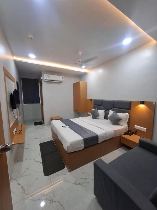 Una habitación de hotel moderna con una cama, mesitas de noche, un escritorio y una silla.
