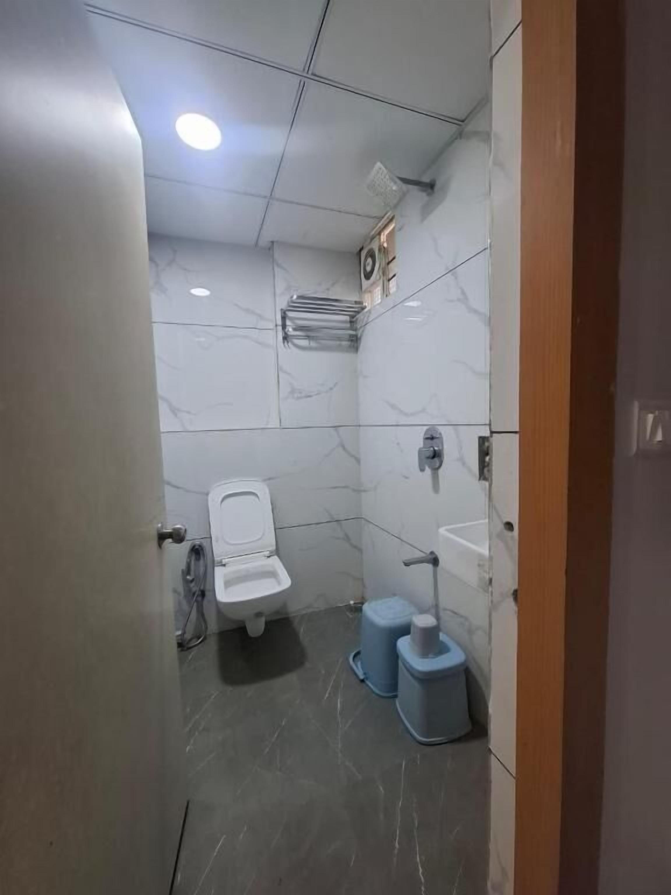 Un baño pequeño y moderno con inodoro, lavamanos y estanterías.