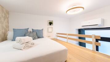 Un dormitorio moderno con una cama bien hecha, un cabecero de madera y un ventanal con vistas.