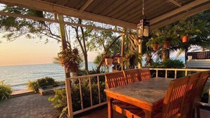 A wooden table and chairs on a tiled patio with a view of the sea. - Pattaya Paradise Beach Resort (Sattahip)