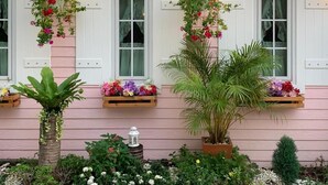 A pink house with white windows and hanging flower baskets. - Pattaya Paradise Beach Resort (Sattahip)