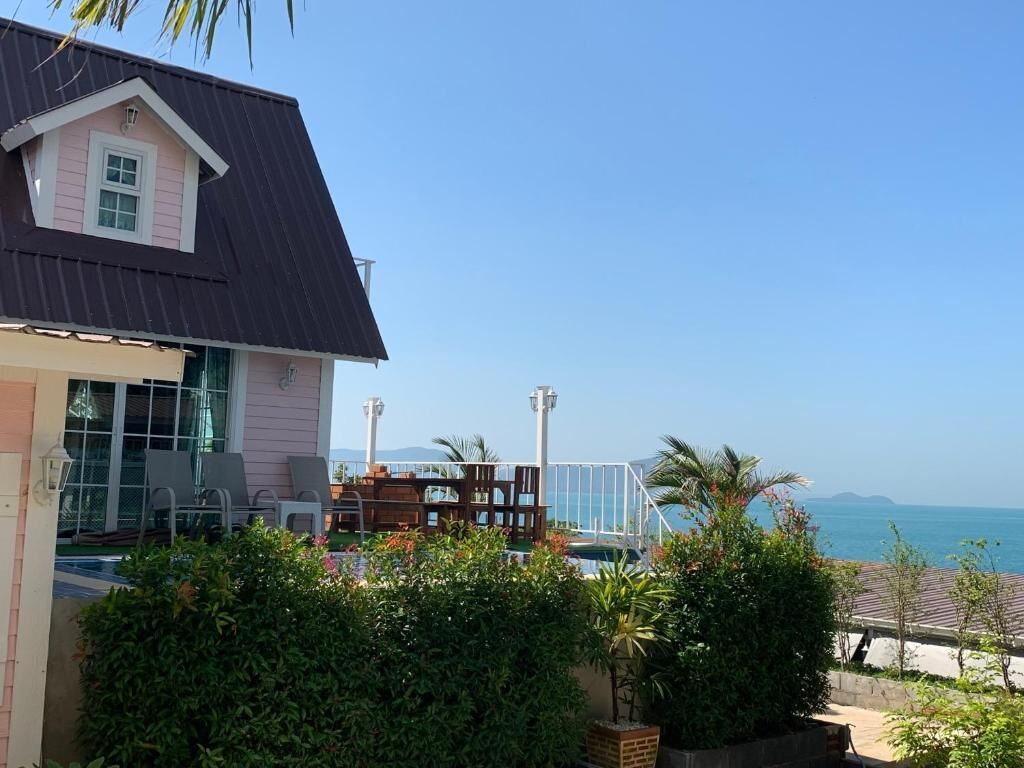 Une propriété située sur la côte, comprenant une grande maison, une piscine et une vue sur la mer.
