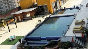 Ein Pool auf dem Dach mit blauer Mosaikverkleidung, umgeben von Topfpflanzen und Sitzmöbeln im Freien.