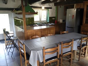 Une cuisine équipée d’une table à manger, de chaises, d’un réfrigérateur et d’une cuisinière.