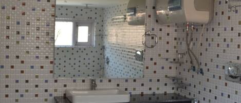 A bathroom with a tiled floor, a sink, a toilet, and a mirror.