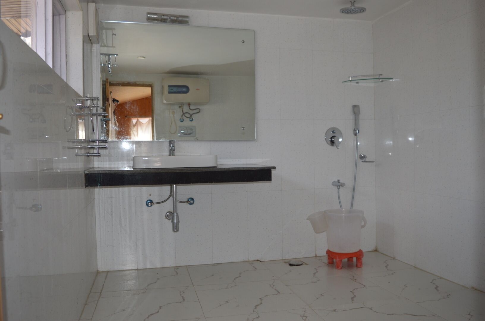 A bathroom with a white sink, mirror, and shower.
