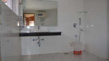 A bathroom with a white sink, mirror, and shower.