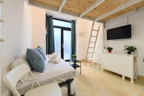 A modern hotel room with a bed, a white desk, a TV, and a window with curtains. - M Rbl180 Acogedor d Plex en Salamanca (Madrid)