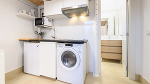 Cozinha compacta com máquina de lavar, micro-ondas e forno embutido.