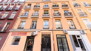 Um edifício de vários andares com varandas, um letreiro de restaurante e aparelhos de ar condicionado.