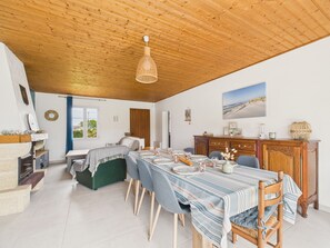 A dining area with a wooden ceiling, a table set for six, and a view of the outdoors through a window. - 800m from beach, lovely house for 6 with garden (Barbâtre)