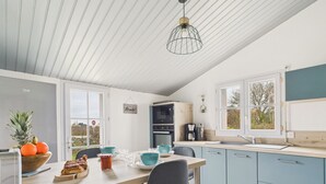 Een moderne keuken met een houten kookeiland, blauwe kastjes en een hangende lamp.