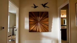A hallway with a wall-mounted artwork featuring birds and a radial pattern. - Wilmington's Luxury Guest House (Wilmington)