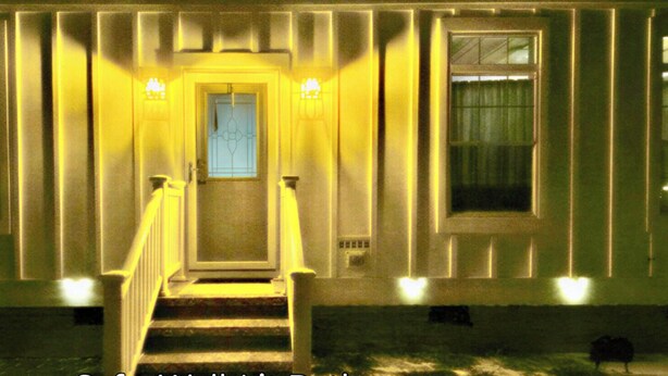 A building with a central staircase, large windows, and a door with a window above it. - Chic Wilmington Retreat—Brand-New, Central Location, Pets Welcome, Fast WiFi! (Wilmington)
