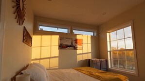 A bedroom with a bed, a window, and a painting on the wall. - Chic Wilmington Retreat—Brand-New, Central Location, Pets Welcome, Fast WiFi! (Wilmington)