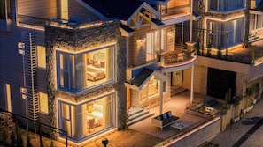 Une maison à plusieurs étages dotée d’un balcon, d’un escalier et d’un patio.