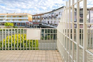 Hotel com varanda, piso de azulejos e vista para a rua.