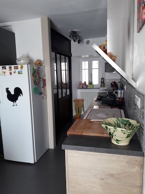 Eine Küche mit Kühlschrank, Schneidebrett und Spüle.