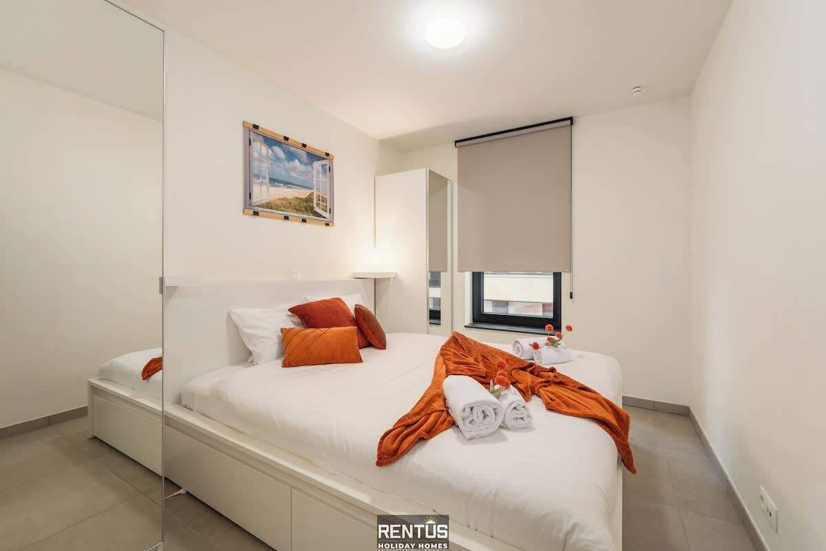 Ein Hotelzimmer mit Bett, Fenster und einem Bild an der Wand.