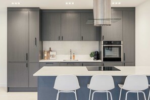 Apartamento, 3 quartos | Cozinha privada | Geladeira grande, micro-ondas, fogão, cooktop