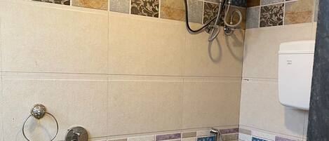 Un bagno con doccia, WC e lavandino.