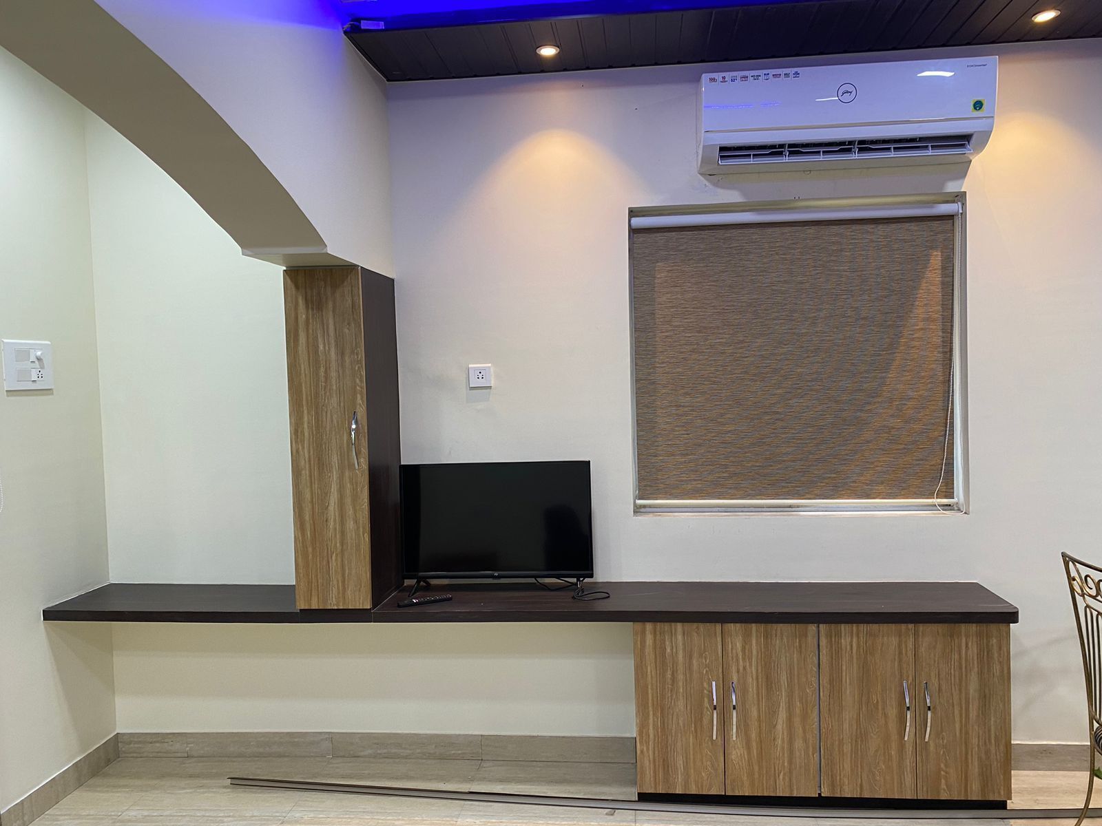 Una cocina moderna con estufa integrada, televisor de pantalla plana y gabinetes de madera.