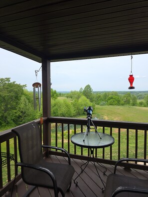 A covered outdoor area with a telescope, chairs, and a hanging red lantern.