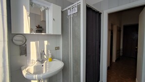 Un baño con lavamanos, espejo y cortina de ducha.