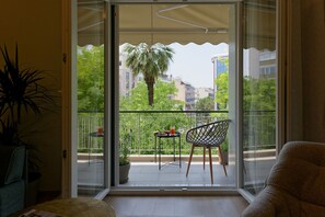 A balcony with a table, chairs, and a potted plant. - Acropolis Deluxe 1BR Apartment (Athens)